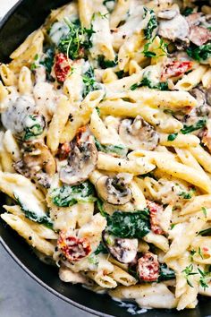 pasta with mushrooms, spinach and tomatoes in a skillet