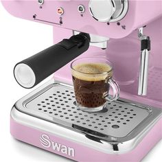 a pink coffee machine with a cup on it