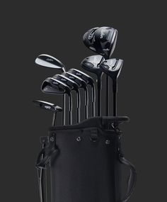 a set of golf clubs and driver's club in a black case on a dark background