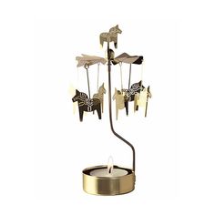 a candle that is inside of a metal holder with horses on it and candlesticks in the shape of animals