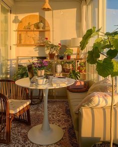 a living room filled with furniture next to a window covered in plants and potted plants