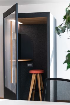 a room with a chair, table and television in it's back door that is open