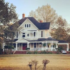 a large white house sitting on top of a lush green field