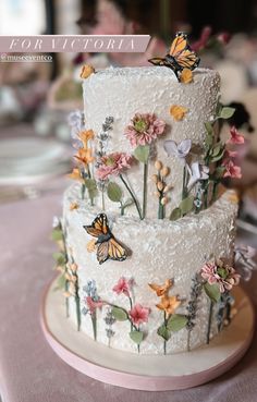 a wedding cake decorated with flowers and butterflies