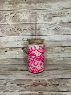 a pink and white cup sitting on top of a wooden table next to a wall