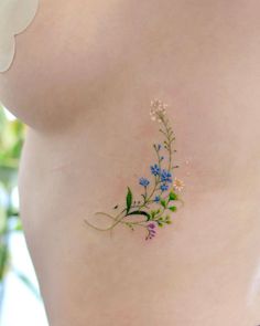 a close up of a woman's stomach with flowers painted on the side and behind her