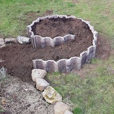 a large pile of dirt sitting in the middle of a field next to some rocks