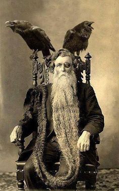 an old black and white photo of a man with a long beard sitting in a chair