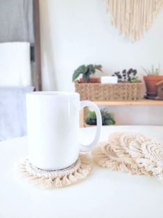 a white coffee cup sitting on top of a table next to a duster and pot holder