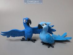 two blue birds are standing next to each other on a gray surface with chinese characters in the background