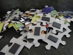 a pile of puzzle pieces sitting on top of a black table next to each other