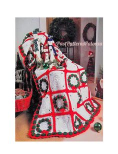 a crocheted christmas blanket with wreaths on it