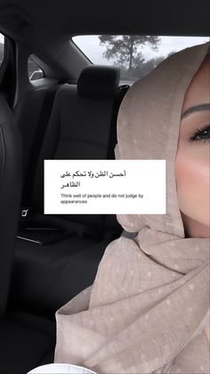 a woman wearing a hijab sitting in the back seat of a car with a note attached to her head