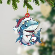 a christmas ornament with a shark wearing a santa hat hanging from a tree