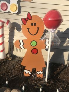 a wooden cutout of a ginger standing next to candy canes