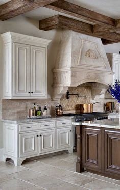 a large kitchen with white cabinets and an island in the middle is decorated with blue flowers