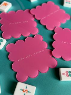 some pink flowers and dices on a blue surface with white letters in the middle