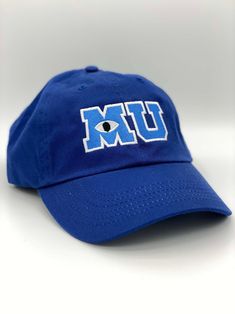 a blue hat with the word um in white letters and an evil eye on it