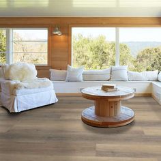 a living room with wood floors and white furniture on the floor is shown in this image