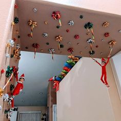 the elf is hanging on the ceiling above the kitchen counter and below it are candy canes