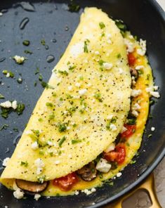 an omelet with tomatoes and cheese in a skillet