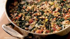 a pot filled with lots of food on top of a wooden table