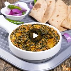 a plate with bread, pita chips and spinach dip in it on a tray