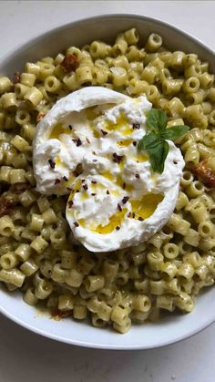 a bowl filled with macaroni and cheese topped with sour cream