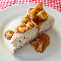 a piece of cheesecake on a plate with caramel sauce and apple toppings