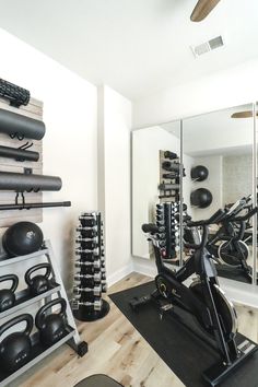 there is a gym with exercise equipment in the room and mirrors on the wall behind it