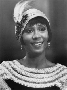 a black and white photo of a woman wearing a headdress