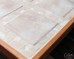 a wooden table with a square shaped tile on it's top and bottom edge