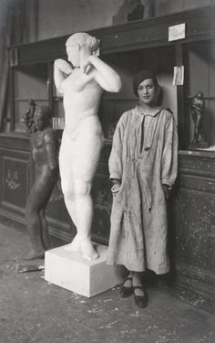 black and white photograph of two women standing next to a statue