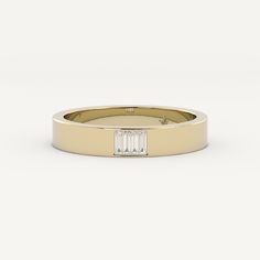 a yellow gold ring with a baguette cut diamond in the center, on a white background