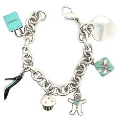 Charming charm bracelet. Made and signed by TIFFANY & CO. Sterling silver bracelet, with a sterling heart charm and five enamel figural charms: a Tiffany bag, a Tiffany box, a cupcake, a high-heeled shoe and a gingerbread man. . 7" long. A perfect gift for the sophisticated young woman in your life. Alice Kwartler has sold the finest antique gold and diamond jewelry and silver for over forty years. Sterling Silver Bracelets Women Tiffany & Co., Elegant Bracelet Tiffany & Co., Tiffany Charm Bracelet Tiffany & Co., Tiffney And Co Jewelry, Tiffany Charm Bracelets, Tiffany Kitchen, Tiffany Charm Bracelet, Blue Bathrooms, Tiffany Bag