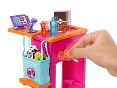 a child's toy desk with toys on it and a hand holding the handle