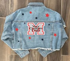 Denim Jacket with Logo and Stars design!  Choose between no glitter stars or glitter stars. - Add up to 2 colors for the stars in the comments section before adding to cart. Also choose between a cropped (as shown) or full length jacket. Jacket color/style may vary slightly, but we will do our best to come the closest to the one shown. <3 Gameday Jean Jacket, Cute Cheer Shirts, Bed Party, Bedazzled Jeans, Custom Jean, Jean Jacket Patches, Custom Jean Jacket, Patch Ideas, Painted Denim Jacket