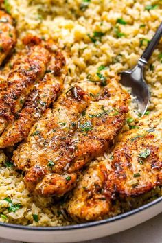 some meat and rice on a plate with a fork