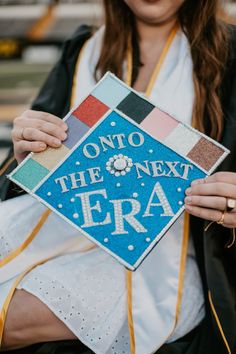 a woman holding up a graduation cap that says on to the next era