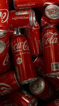 a pile of coca - cola cans sitting next to each other on top of each other