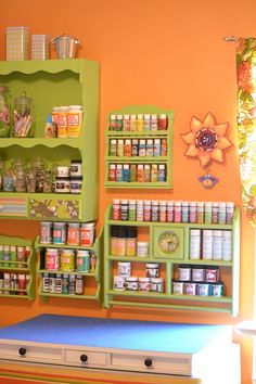 an orange room with green shelves filled with spices