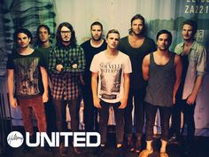 a group of young men standing next to each other in front of a sign that says united