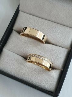 two gold rings with diamonds in a box