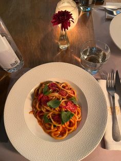 a white plate topped with pasta and sauce