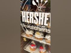 there is a sign that says hershe kitchens in front of some cupcakes