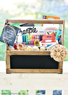 a wooden crate filled with crafting supplies on top of a white porch rail next to a window