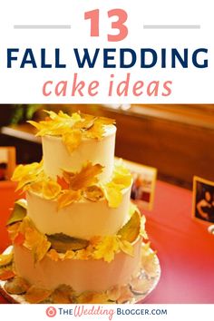 a three tiered wedding cake with yellow leaves on the top and bottom, sitting on a red table