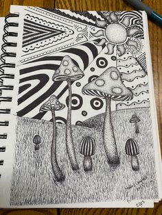 a drawing of three mushrooms on a table next to a pen and paper with an abstract background