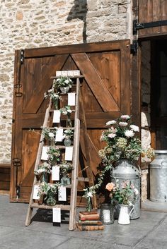 a wooden ladder with flowers on it next to an old door