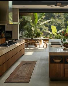 a kitchen with wooden cabinets and an island in front of the counter top is surrounded by greenery